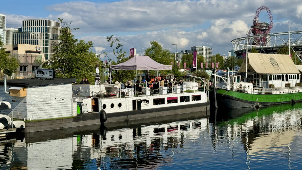 Boats, as floating cafe's, at Hackney Wick with the Queen Elizabeth Olympic Park in the background.