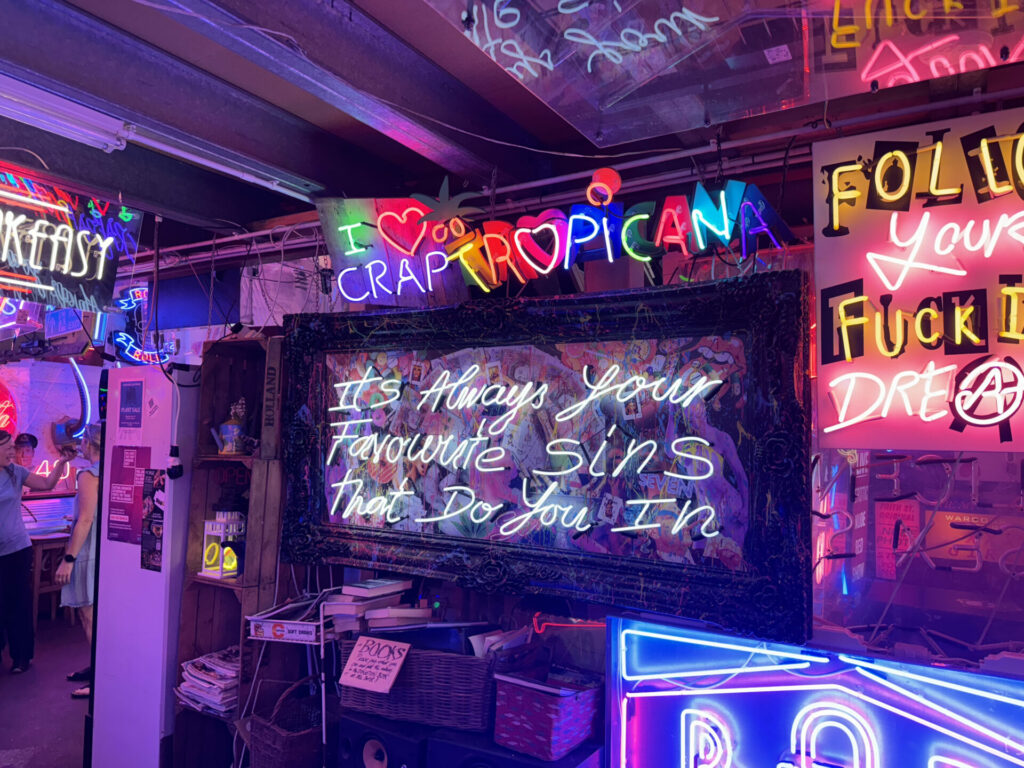A white neon sign saying Your Favourite Sins at God's Own Junkyard - a museum dedicated to neon signs.