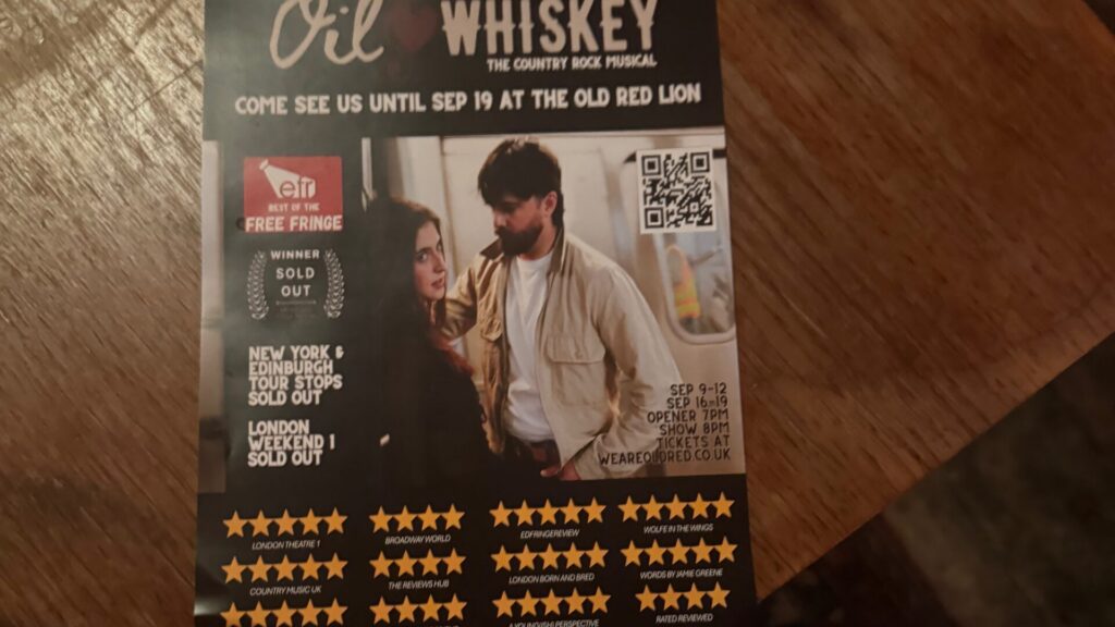 A promotional flyer for "Oil & Whiskey, The Country Rock Musical" shows a couple in a tense moment, with text advertising its run at the Old Red Lion pub theatre until 19 September, sold-out notices, and a row of five-star ratings along the bottom.
